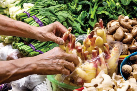 Stallholder is organising vegetables in Link REIT Wo Che Market. Stallholder is organising vegetables in Link REIT Wo Che Market.